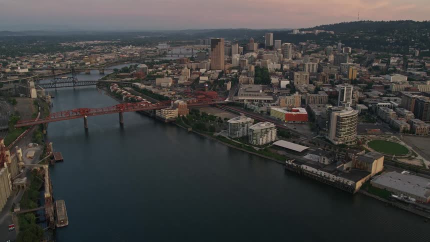 Aerial panoramic view of Downtown Portland Oregon at twilight revealing the city's high-rise buildings and the Fremont Bridge spanning the Willamette River