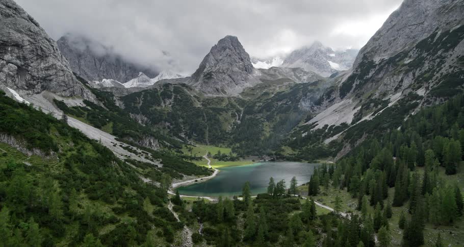 Horizon with mountains covered in snow vegetation forests and a blue lake in the middle