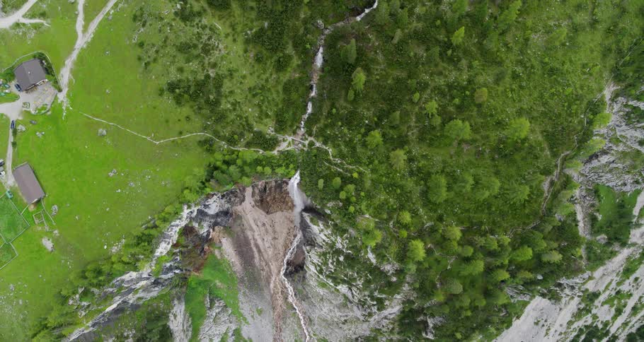 House on a green hillside near cliffs