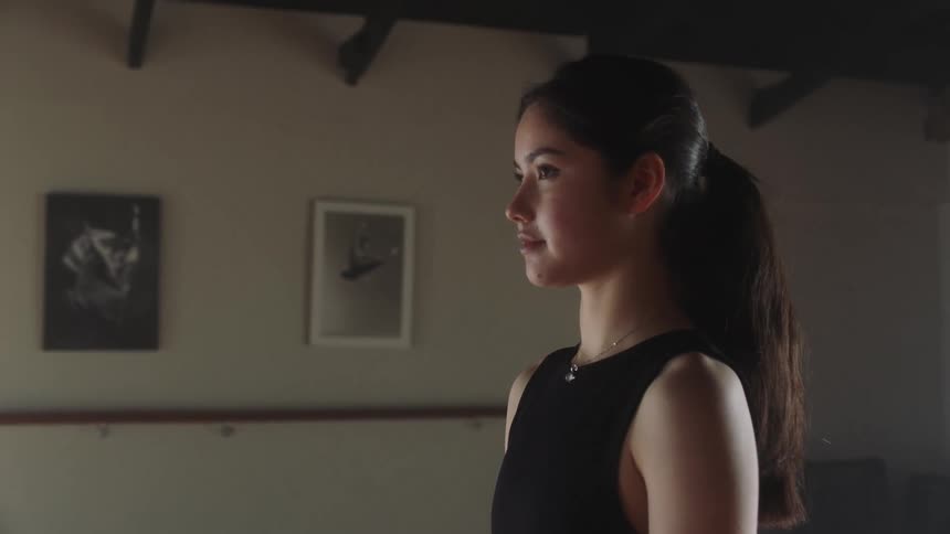 Young woman taking a deep breath and opening her eyes with a determined expression