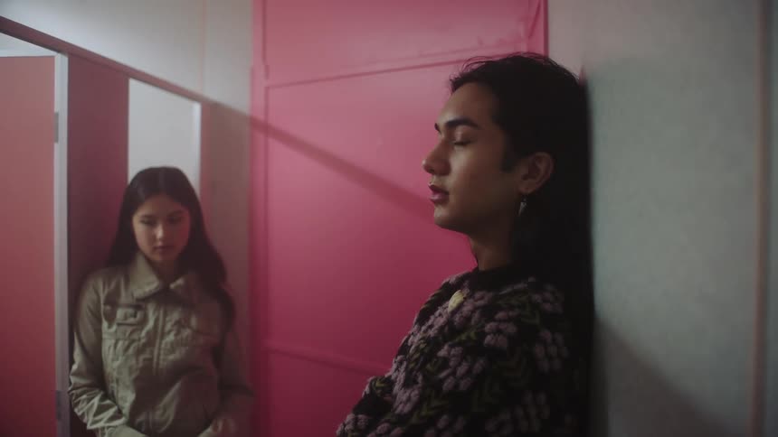 Teenager girl and adult androgynous person having a conversation in a bathroom