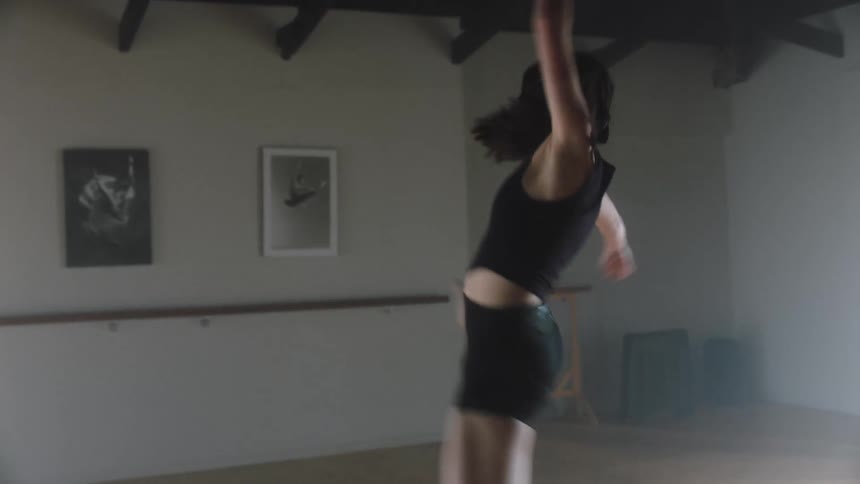Female dancer spins and leaps toward the barre