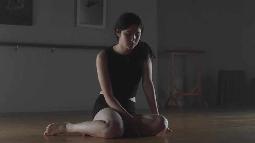 Female with a sad face sit on on a hard wood floor