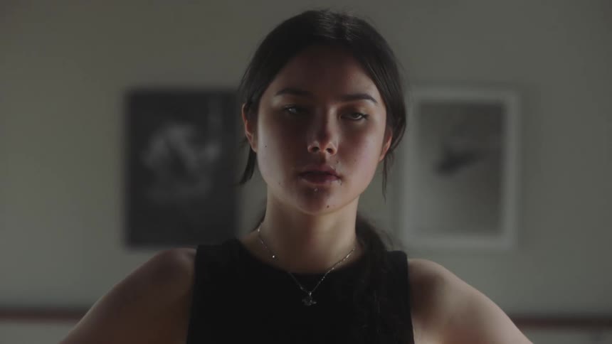 Young adult woman shrugging her shoulders with a determined expression