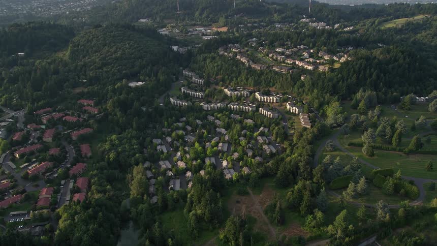 an aerial view of a hillside apartment building in Southwest Portland Oregon during sunset showcasing the vibrant colors of the city and its surrounding green spaces
