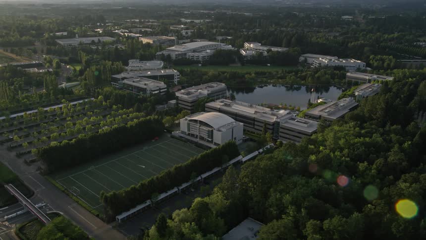 Aerial footage of Nike Headquarters in Beaverton Oregon during sunset showcasing the surrounding office buildings and industrial area
