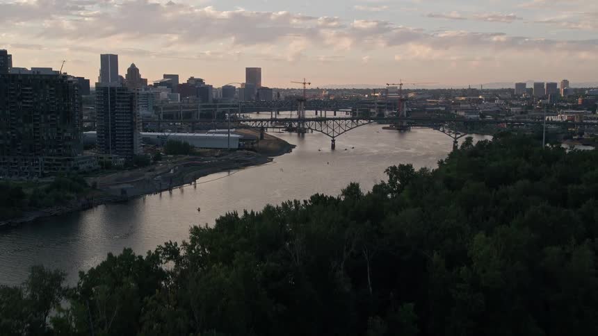 an aerial view at dusk of Downtown Portland Oregon with bridges and the Willamette River captured during a vibrant summer sunset