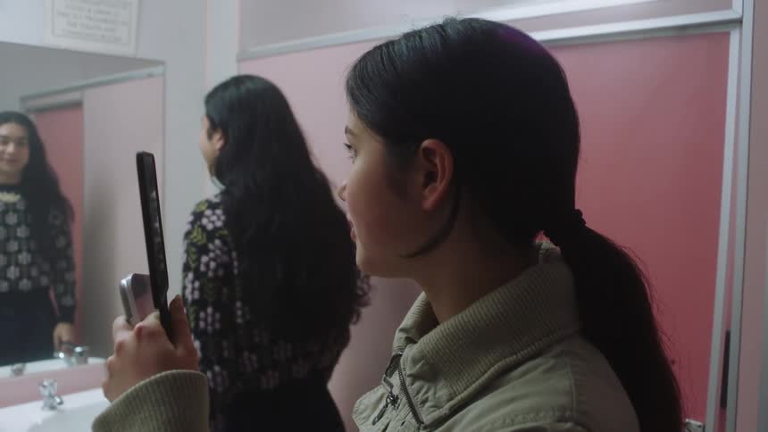 Two people doing makeup in an indoor setting