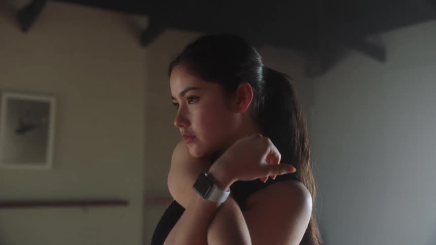 A young woman exercises in an empty room