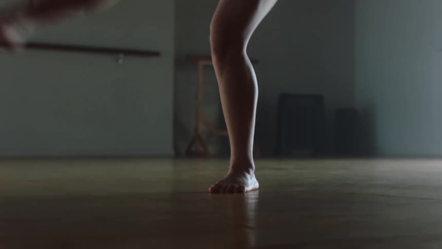 Dancers feet pointe and pirouette across a wood floor