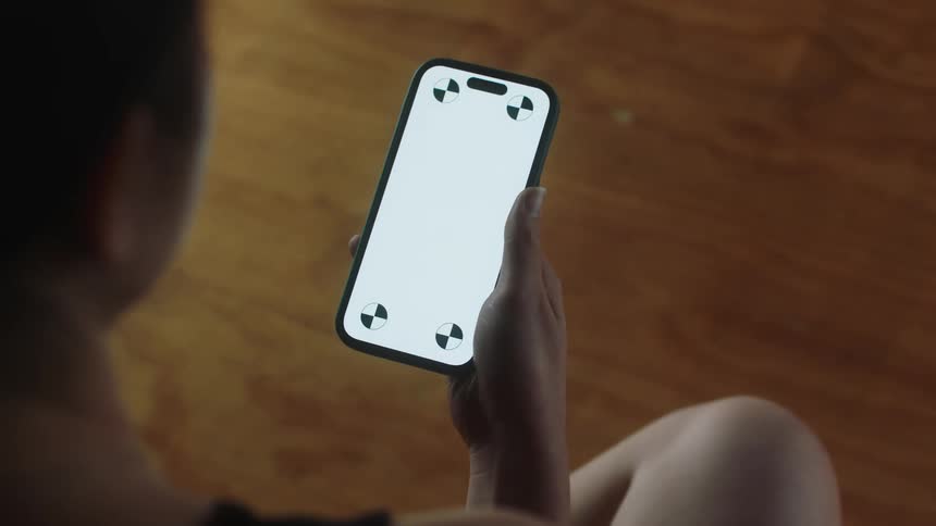 A woman picks up her smart phone and looks at the screen