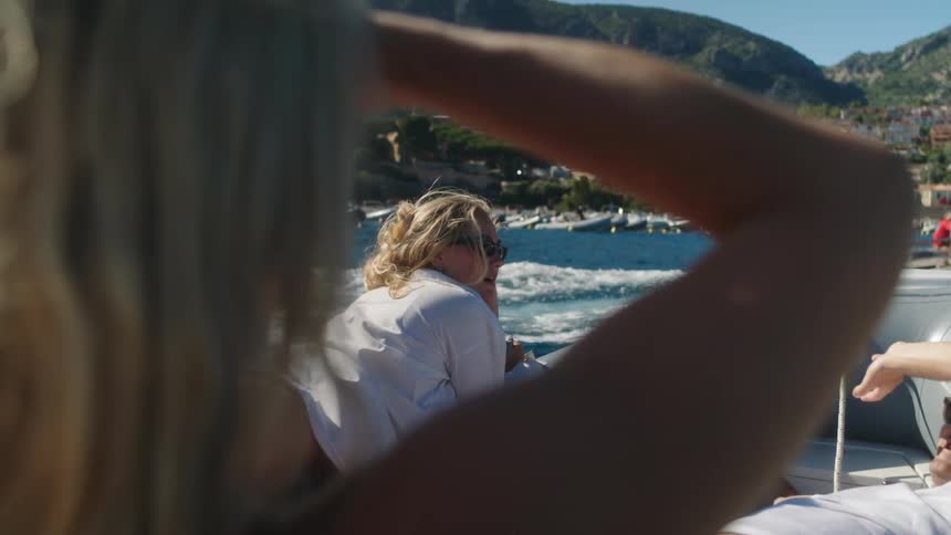 Three people inside the boat and some of them are lying down and chatting