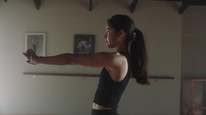 Young woman with a ponytail stretching her upper body