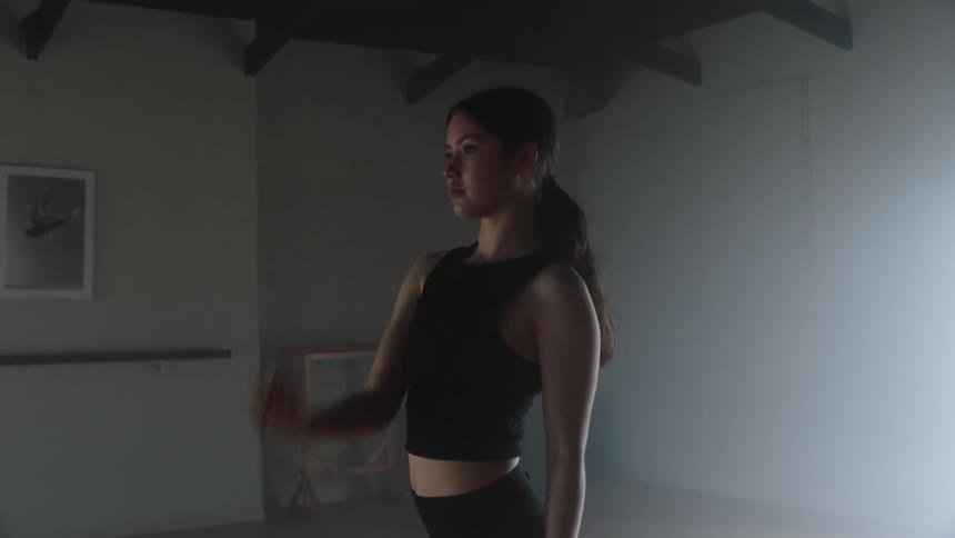 A woman wearing a black top and a black short doing stretching exercise