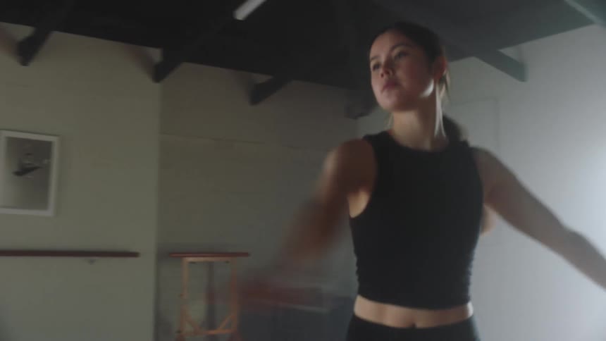 Young woman dancing and gesturing her arms in ballet style