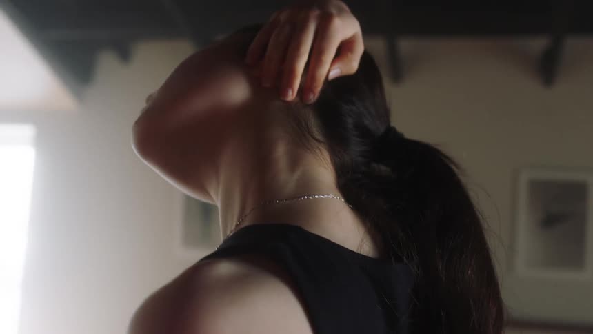 A woman dressed in black exercise clothing stretching her body in a hall