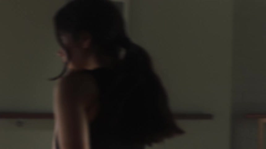 A teenage female practices various dance moves while alone