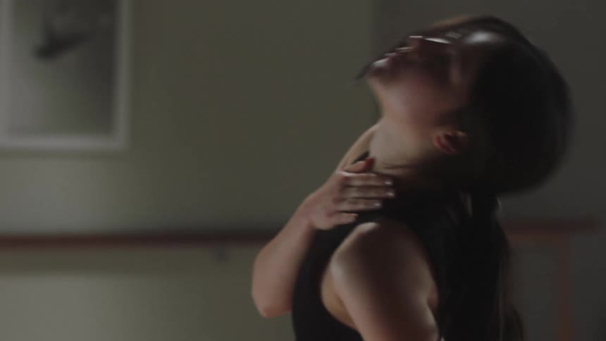 A young lady in a room moving her body around and doing exercise