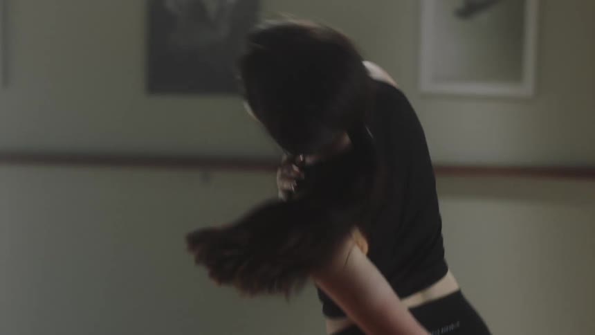 Female performer dancing indoors during day time
