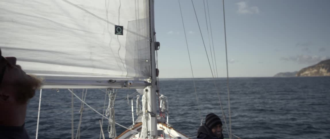Two people are on a sailing boat