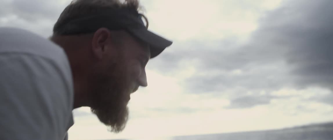 A man is talking and smiling by the water