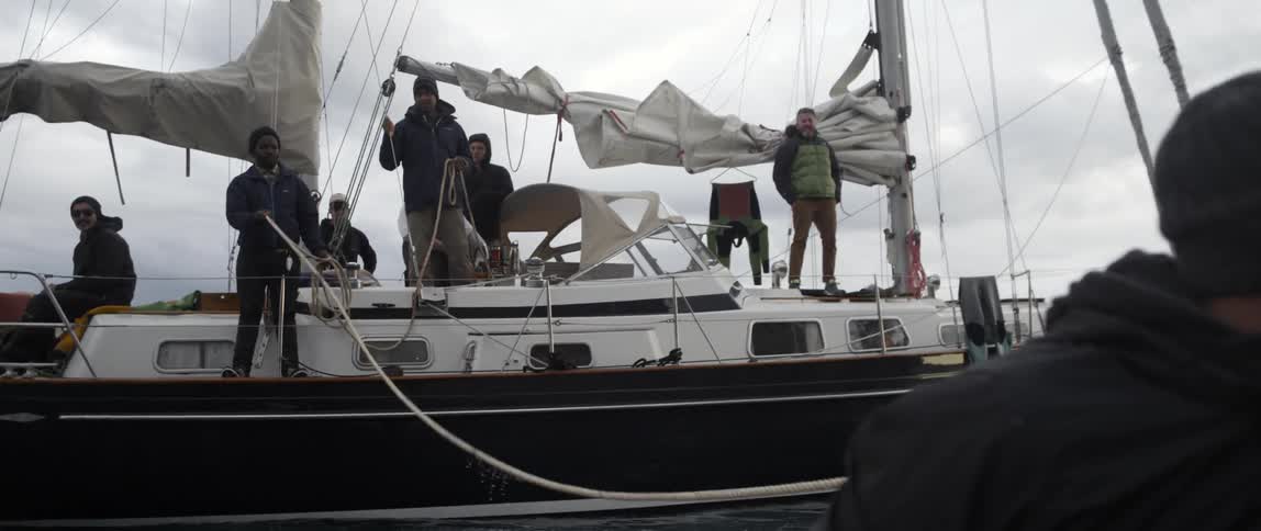 A man walks away from a boat with people on it