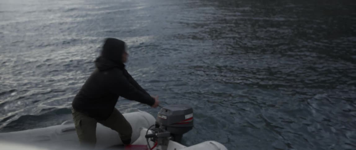 A man starts the motor on a raft