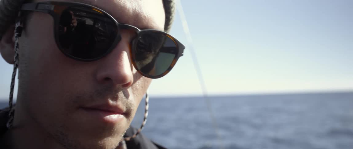 A man is wearing sunglasses on a boat