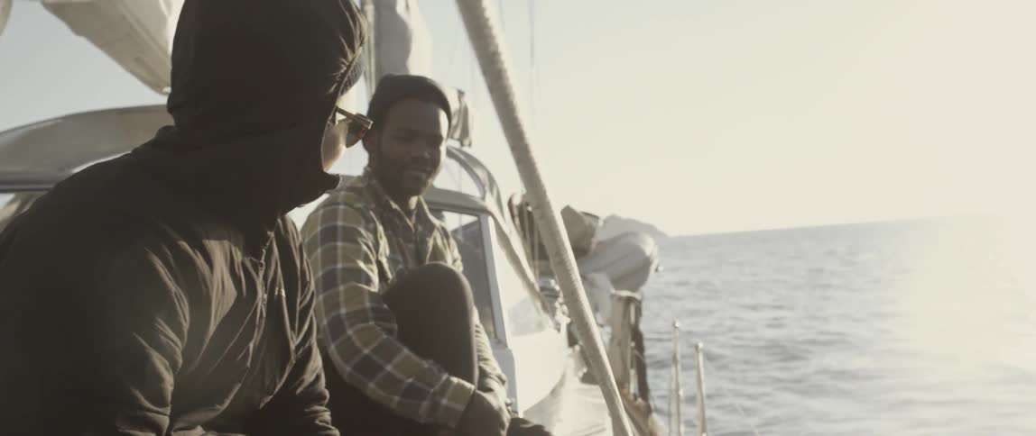 People are sitting on a sailing boat talking