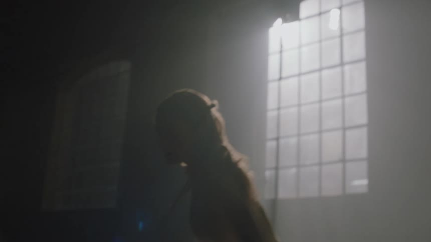 A woman wearing ballerina cloth dancing in a dim lit room