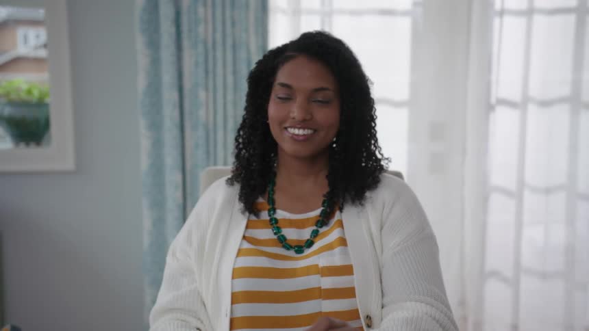 Woman smiles after working on a laptop indoor