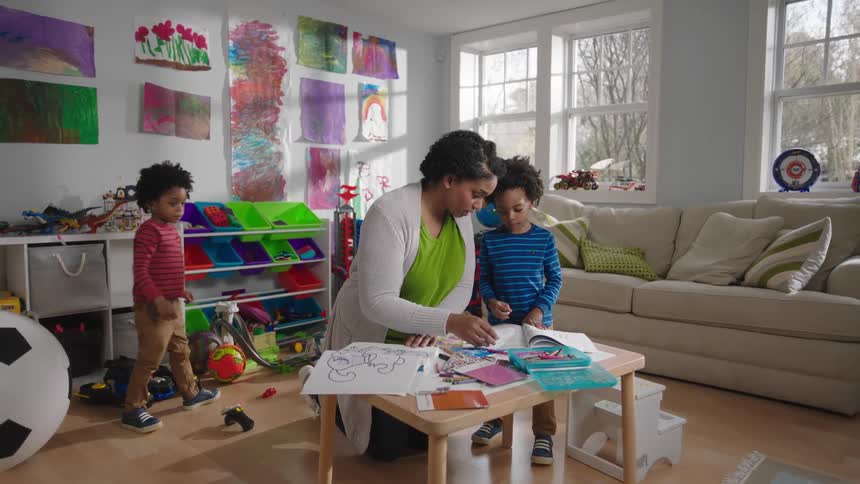 Mother and sons playing with toys in the living room
