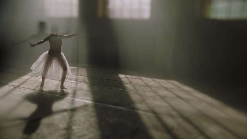 A woman in a skirt dancing ballet in a room that is lit with sunlight coming from the window
