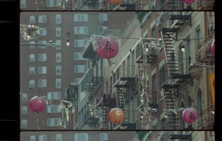 Lights and colored balloons are strung across the street in an asian highrise neighborhood