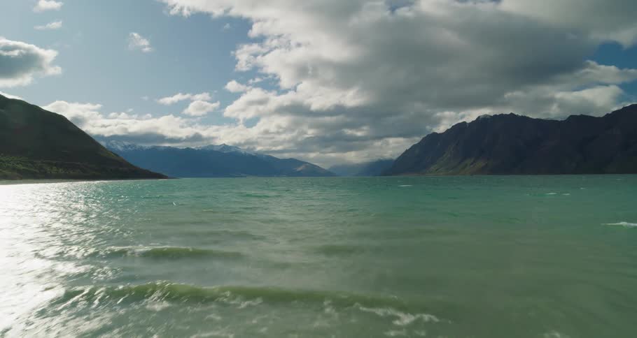 Man walking beside the sea with mountains