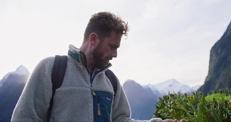 A man observes plants in nature during the day