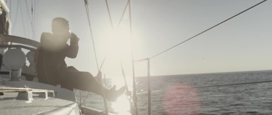 A man has a drink sitting on a boat