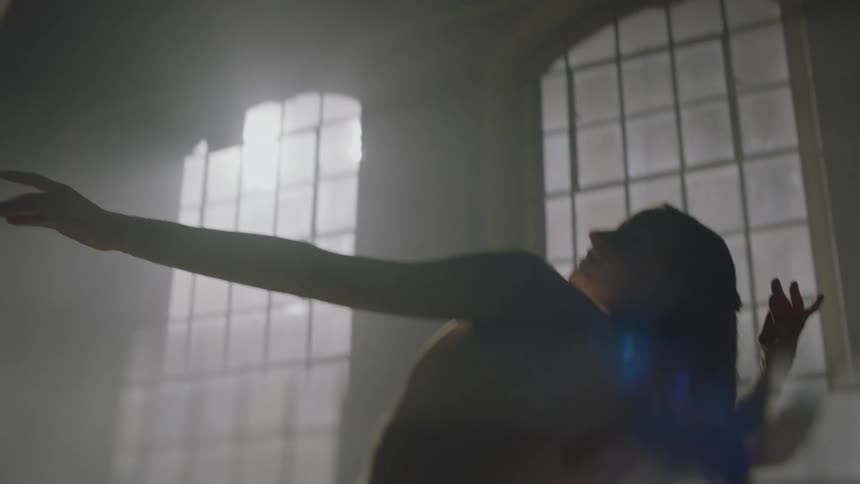 A ballerina practicing in a dark room