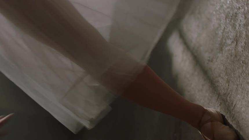 Female dancer moves in front of a window indoors