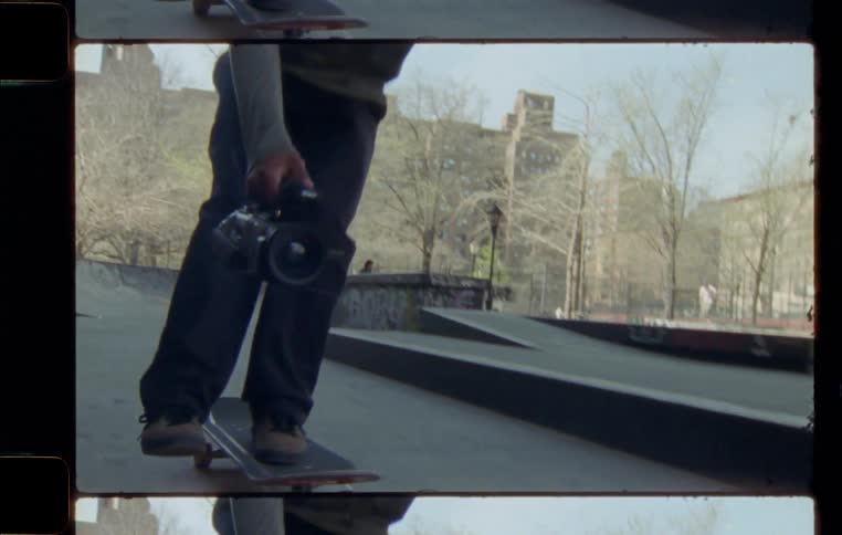 Skateboarder with a video camera at a skate park in the city during the day