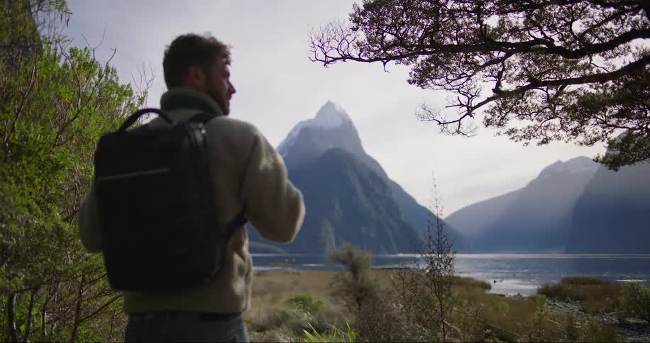 An explorer standing and contemplating by the river bank