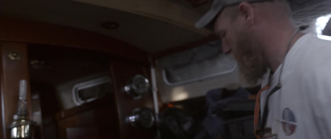 A turns and walks through the cabin of a boat