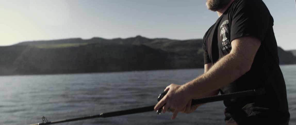 Two men are on a boat fishing