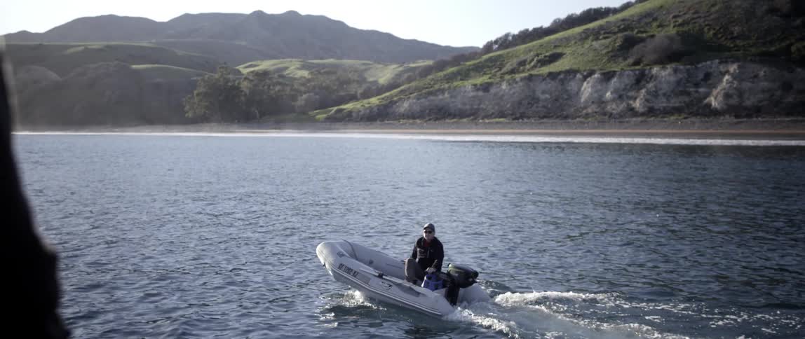 A man rides a raft in the water below