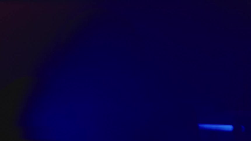 Silhouettes of people dancing at a night club under colored lights