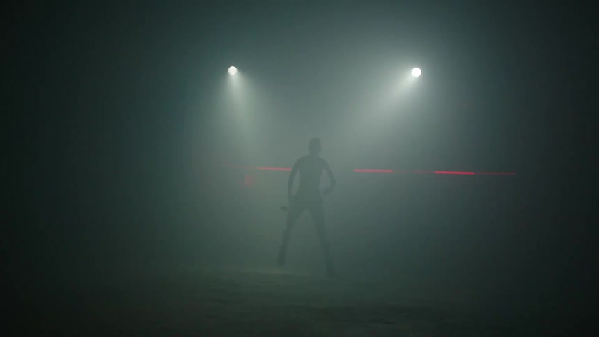 Dancer performs silhouetted against flashing white and red lights