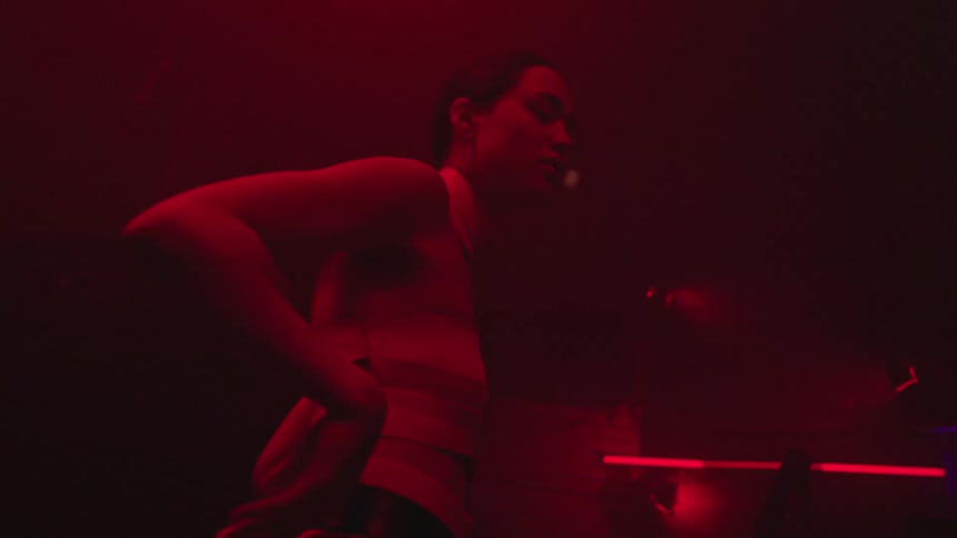 A woman in a club giving herself to her dancing under white and purple strobe lights