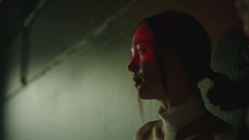 Two women sitting down quietly indoors under red and white lights