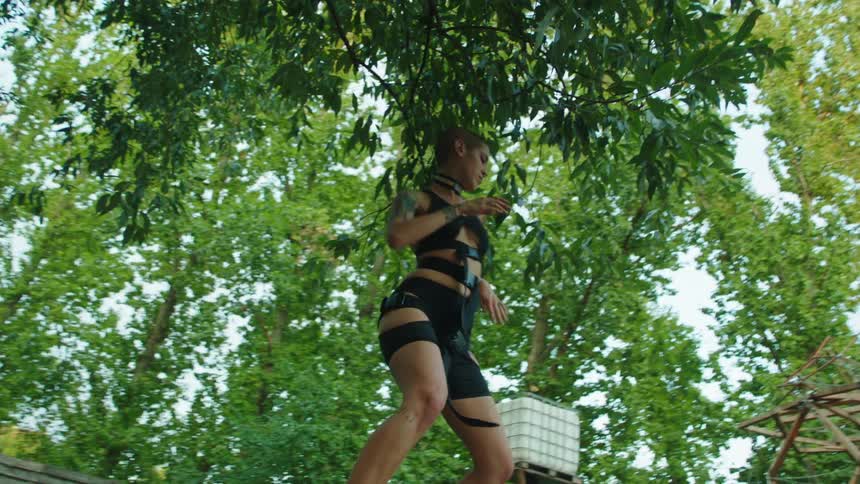 A woman is dancing by the trees