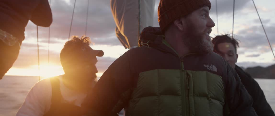 Men are on a boat talking at dawn